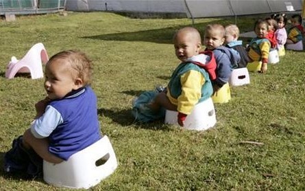 Children of Colombians working in a farm that grows flowers for export take a group lesson in potty-training 