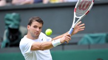 Grigor Dimitrov delivers a precise backhand drop shot against Andy Murray at the Wimbledon quarterfinals