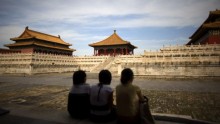 Three tourists taking in the view at the Forbidden City in Beijing, China.