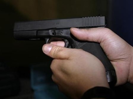 A unidentified man holds a Glock 9 mm pistol