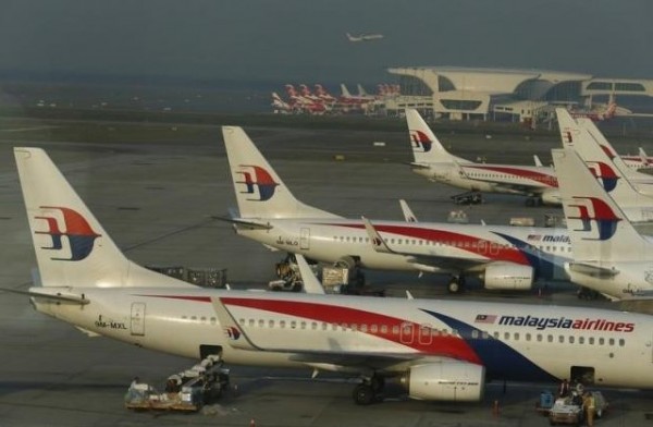 Ground crew work among Malaysia Airlines planes on the runway at Kuala Lumpur International Airport (KLIA) in Sepang July 25, 2014.