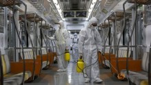 Workers in full protective gear disinfect the interior of a subway train at a Seoul Metro's railway vehicle base in Goyang, South Korea, June 9, 2015
