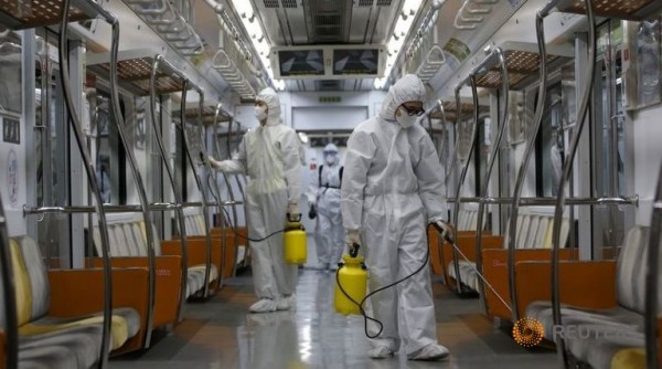Workers in full protective gear disinfect the interior of a subway train at a Seoul Metro's railway vehicle base in Goyang, South Korea, June 9, 2015