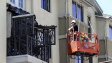 Workmen examine the damage at the scene of a 4th-story apartment building balcony collapse in Berkeley, California June 16, 2015.