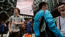 Mainland Chinese visitors stand outside a Burberry store at Tsim Sha Tsui shopping district in Hong Kong January 18, 2013.