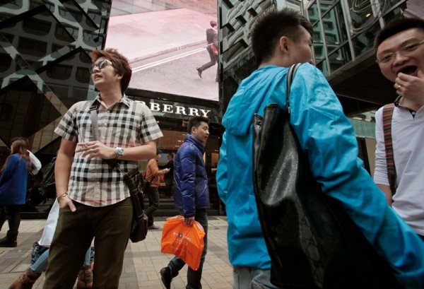 Mainland Chinese visitors stand outside a Burberry store at Tsim Sha Tsui shopping district in Hong Kong January 18, 2013.