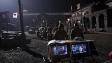 Actors in Japanese military uniforms watch a replay of a scene during the filming of an anti-Japanese World War Two film