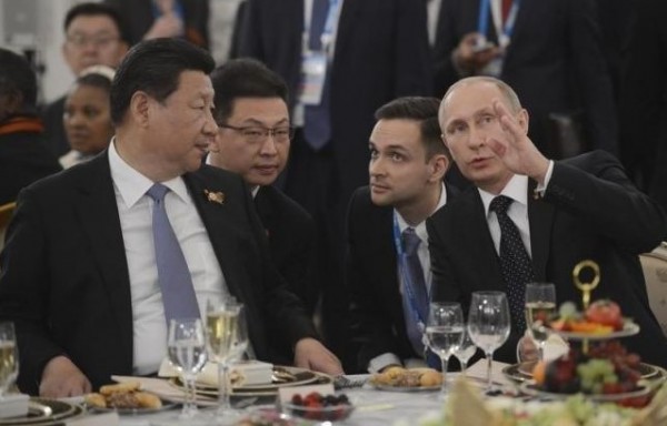 Russian President Vladimir Putin (R) and his Chinese counterpart Xi Jinping (L) speak at a reception hosted by Putin in Moscow, Russia, May 9, 2015.