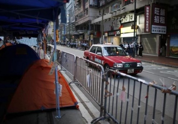 A taxi drives past tents at a protest site after police removed some barricades, at the commercial area of Causeway Bay in Hong Kong October 14, 2014.