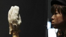 A woman looks at a sequined glove that once belonged to the late pop star at the MJ46 Japan Tour, an exhibition showcasing various Michael Jackson items, in Tokyo November 9, 2009.