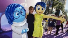 Cast member Amy Poehler (C) poses with the characters of Sadness and Joy (R) at the premiere of 