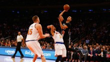 Minnesota Timberwolves shooting guard Kevin Martin (R) shoots over New York Knicks' Shane Larkin