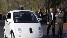 Google's Chris Urmson (R) shows a Google self-driving car to U.S. Transportation Secretary Anthony Foxx (L) and Google Chairman Eric Schmidt (C) at the Google headquarters on February 2, 2015 in Mountain View, California. 