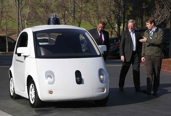 Google's Chris Urmson (R) shows a Google self-driving car to U.S. Transportation Secretary Anthony Foxx (L) and Google Chairman Eric Schmidt (C) at the Google headquarters on February 2, 2015 in Mountain View, California. 