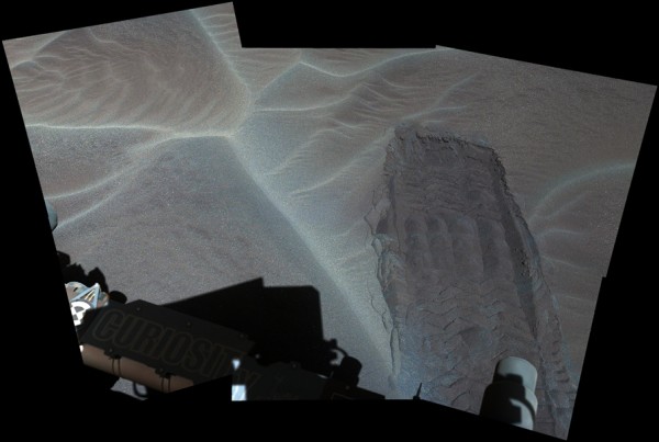 A wheel track left by NASA's Curiosity Mars rover exposes underlying material in a shallow sand sheet in this Dec. 2, 2015, view from Curiosity's Mast Camera (Mastcam).
