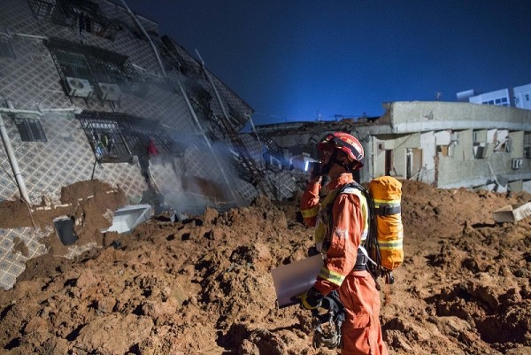 A rescuer surveying the site where the landslide took place in Shenzhen, China