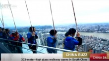 Chinese tourists holding onto their rope and secured with harness take a look at the overlooking city view