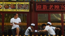 Chefs  sitting outside a restaurant in Beijing city. 