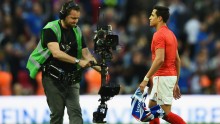A TV cameraman films Arsenal winger Alexis Sanchez