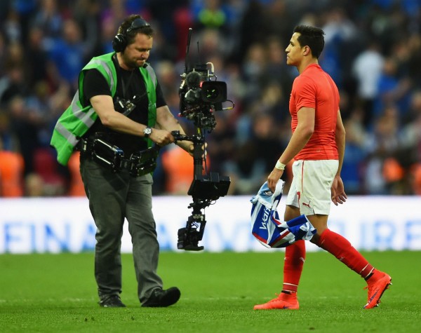 A TV cameraman films Arsenal winger Alexis Sanchez