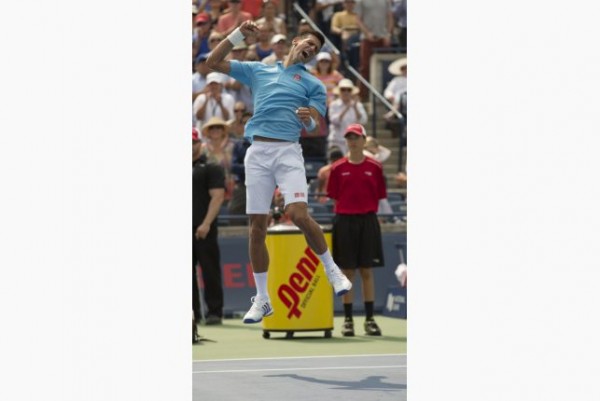 A jubilant Novak Djokovic jumping and throwing his fist in the air after defeating Gael Monfils in a three set thriller