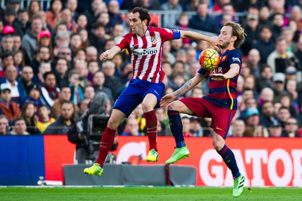 Atletico Madrid center back Diego Godin (L) competes for the ball against Barcelona's Ivan Rakitic