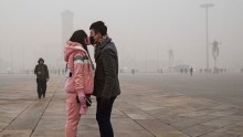 A Chinese Couple Wears Masks as They Kiss.