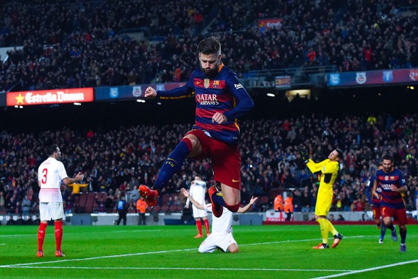 Barcelona defender Gerard Pique jumps after scoring his team's second goal against Sevilla