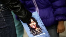 A mourner holds an obituary displaying a picture of shooting victim Renisha McBride during her funeral service in Detroit, Michigan 