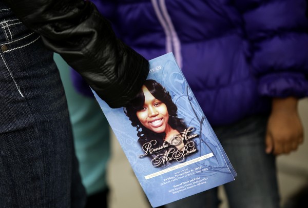 A mourner holds an obituary displaying a picture of shooting victim Renisha McBride during her funeral service in Detroit, Michigan 