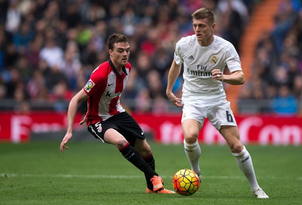 Real Madrid midfielder Toni Kroos (R) competes for the ball against Athletic Bilbao's Javier Eraso.