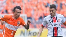 Shandong Luneng winger Wang Yongpo (L) competes for the ball against FC Seoul's Osmar Barba