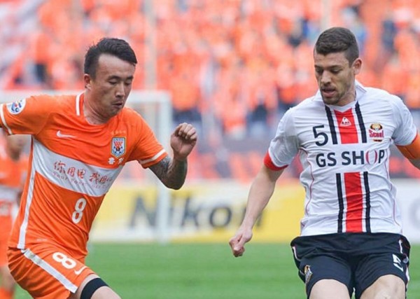 Shandong Luneng winger Wang Yongpo (L) competes for the ball against FC Seoul's Osmar Barba