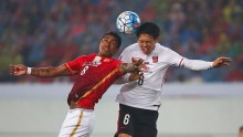 Guangzhou Evergrande midfielder Paulinho competes for the ball against Urawa Red Diamonds' Wataru Endo