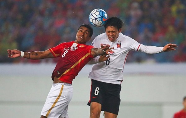 Guangzhou Evergrande midfielder Paulinho competes for the ball against Urawa Red Diamonds' Wataru Endo