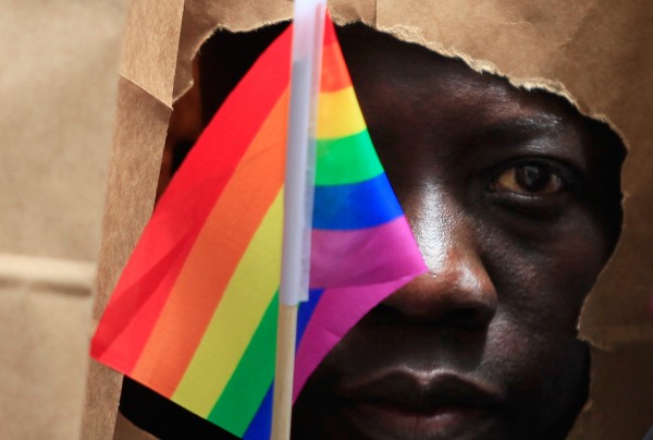 An asylum seeker from Uganda covers his face with a paper bag in order to protect his identity as he marches 