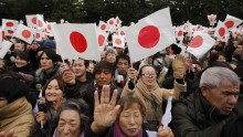 Japanese citizens wave Japanese national flags.
