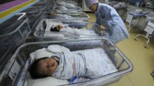 A nurse takes care of newborn babies at a hospital in Hefei, China, April 21, 2011.