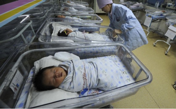 A nurse takes care of newborn babies at a hospital in Hefei, China, April 21, 2011.