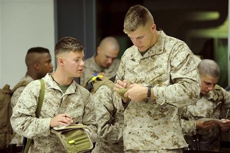 United States Marines of Fox Company, 2nd Battalion, 3rd Marine Regiment complete Australian Customs paperwork as they arrive at a Royal Australian Air Force Base in Darwin.