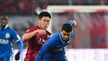 Shanghai SIPG's Cai Huikang (L) competes for the ball against Shanghai Shenhua's Giovanni Moreno during the recent Shanghai derby in the CSL