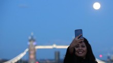 Woman takes selfie as supermoon rises
