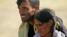 A displaced man and a woman from the minority Yazidi sect, fleeing violence from forces loyal to the Islamic State in Sinjar town