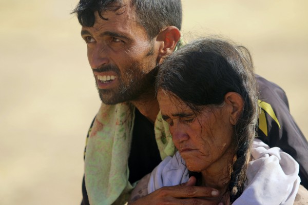 A displaced man and a woman from the minority Yazidi sect, fleeing violence from forces loyal to the Islamic State in Sinjar town