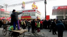  Local residents watch the opening ceremony for a new McDonald's drive-thru facility adjacent to a Sinopec gas station on Jan. 19, 2007 in Beijing, China. (Photo: Guang Niu/Getty Images)