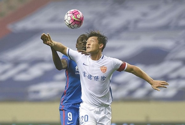 Yanbian Funde defender Cui Min competes for the ball against Shanghai Shenhua's Demba Ba during their 2016 CSL season opener