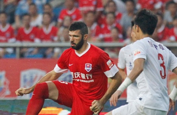 Chongqing Lifan forward Emanuel Gigliotti (L) competes for the ball against Shanghai SIPG's Kim Ju-young