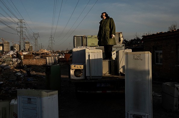 A Chinese laborer stands on a truck with appliances to be recycled in the Dong Xiao Kou village on Dec. 12, 2014 in Beijing, China. (Photo: Kevin Frayer/Getty Images)