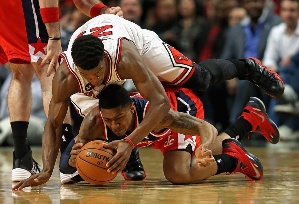 Chicago Bulls wingman Jimmy Butler goes over the back of Washington Wizards' Bradley Beal while competing for the ball