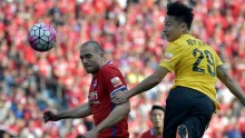 Chongqing Lifan defender Goran Milovic (L) competes for the ball against Guanzhou Evergrande's Gao Lin